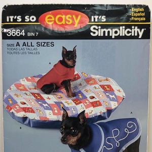 May include: A Simplicity sewing pattern envelope, number 3664, featuring instructions for pet apparel. The cover displays two small dogs wearing a red coat and a blue coat with white trim, alongside a round, multi-colored patterned pet bed.