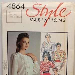 May include: A sewing pattern envelope labeled 4864 Style Variations featuring a white blouse with ruffles and long sleeves. The cover displays illustrations of five different blouse designs with various patterns and necklines, including polka dots and floral prints.