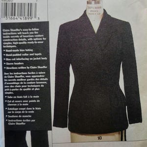 May include: A black jacket pattern by Claire Shaeffer, displayed on a mannequin. The pattern number is V8428, size D (12-14-16). The image includes text detailing couture construction techniques and the Fabricland Orangeville logo.