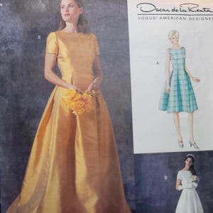 Pode incluir: Um envelope de molde de costura Vogue American Designer de Oscar de la Renta, número 2512, apresentando ilustrações e fotografias de dois estilos de vestido: um vestido sem mangas xadrez até o joelho e um vestido longo dourado ou branco.
