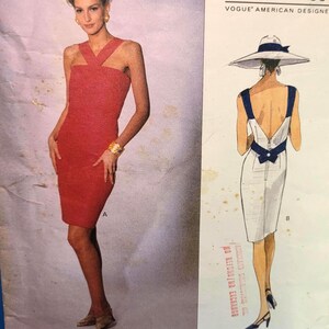Peut inclure: Patron de couture Vogue Patterns avec une robe rouge et une robe blanche avec un nœud bleu marine au dos. Le patron comprend le texte "BILL BLASS" et "VOGUE AMERICAN DESIGNER".