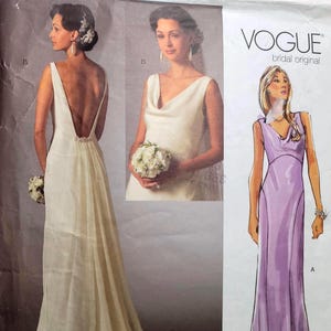 May include: Vogue Bridal Original sewing pattern V2965 for a floor-length gown. The package displays a white dress with a deep back and cowl neckline, alongside a purple illustration of the same dress design, featuring size range 16-18-20.
