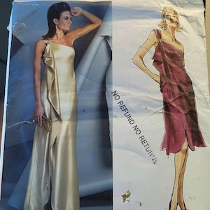 Könnte beinhalten: Vogue American Designer Schnittmuster V2881 mit einem One-Shoulder-Abendkleid mit hohem Schlitz. Das Muster enthält eine Zeichnung des Kleides und den Text "NO REFUND NO RETURNS".