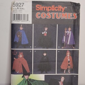 Może przedstawiać: Koperta z wykrojem krawieckim Simplicity Costumes, numer 5927, zawierająca ilustracje różnych kostiumów dziecięcych, w tym peleryn, płaszczy i strojów tematycznych. Opakowanie zawiera napis Simplicity COSTUMES oraz kod kreskowy.
