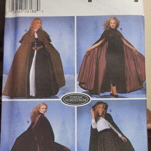 May include: Simplicity sewing pattern 5794 featuring cape designs. The pattern includes multiple cape styles, with variations in color and design. The pattern is for sizes XS, S, M, and L.