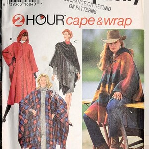 May include: Simplicity sewing pattern 9223 for a 2 hour cape and wrap. The envelope features illustrations of three different cape styles: a red hooded cape, a black wrap, and a plaid wrap, plus a photo of a multi-colored striped cape.