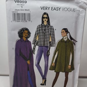 May include: A Very Easy Vogue sewing pattern envelope V8959 in size Y (Xsm-Sml-Med). The front features illustrations of three different cape styles: a black and white houndstooth cape, a long purple cape, and a shorter olive green cape.