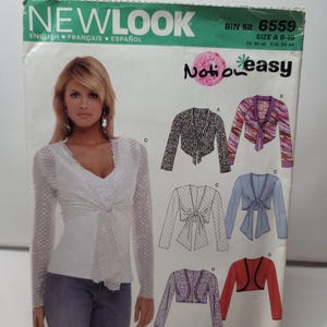 May include: A New Look sewing pattern envelope 6559 for a tie-front cardigan in size A 8-18. The cover features a photograph of a person wearing a white long-sleeved lace cardigan and illustrations of four variations labeled A, B, C, and D.
