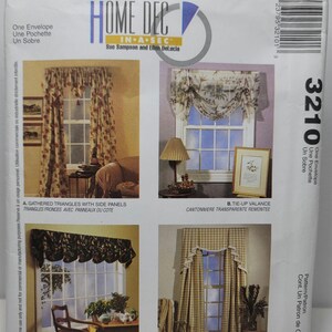 May include: A McCall's Home Dec sewing pattern envelope 3210 featuring four window treatment designs: gathered triangles with side panels, a tie-up valance, a fluted valance, and a cascade cornice with side panels, all displayed on a white background.