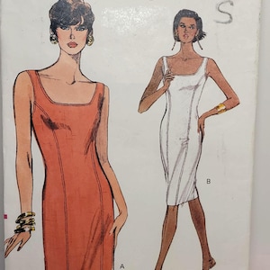Peut inclure: Une pochette de patron de couture Very Easy Very Vogue 7796 pour les tailles 12-14-16. Le devant présente des illustrations de deux robes sans manches à encolure dégagée avec des coutures verticales, une orange et une blanche, avec un code-barres.