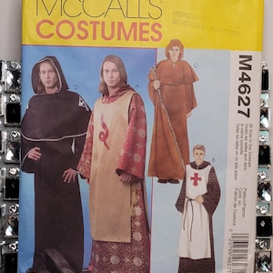 May include: McCall's Costumes sewing pattern envelope M4627 featuring illustrations of four different hooded robe and tunic outfits. The yellow and blue envelope displays models wearing black, tan, brown, and patterned medieval-style garments.