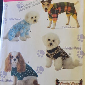 Può includere: Modello Simplicity 3939 per abbigliamento per cani. Il modello presenta vari outfit per cani, tra cui una tuta a quadri, un pigiama blu floreale, un top con stampa leopardata e una camicia verde acqua con motivo a cuore. Taglie A, S, M, L.