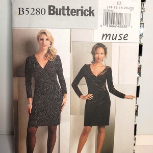 Puede incluir: Un sobre de patrón de costura Butterick B5280 para un vestido con cuello en V y mangas largas. La portada muestra dos variaciones: una en tela negra con un pequeño patrón blanco y otra en tela marrón oscuro tipo terciopelo, ambas hasta la rodilla.