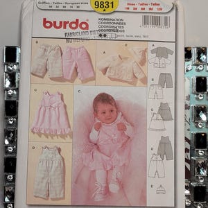 Może przedstawiać: Koperta z wykrojem krawieckim Burda 9831 dla niemowląt, zawierająca ilustracje spodni, kurtki, czapki i sukienki. Okładka przedstawia zdjęcie niemowlęcia w różowej sukience i białych rajstopach, z tekstem zawierającym rozmiary 56-80 oraz 1M-12M.