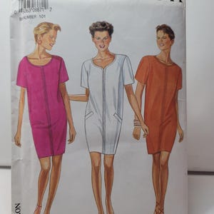 Puede incluir: Un sobre de patrón de costura New Look 0671 con ilustraciones de tres vestidos rectos de manga corta en magenta, blanco y naranja. Cada vestido tiene una costura vertical central, un escote redondo y dos bolsillos delanteros inclinados. El texto incluye 0671, NEW LOOK, SIZE 8-18 y PATRON PATTERN.