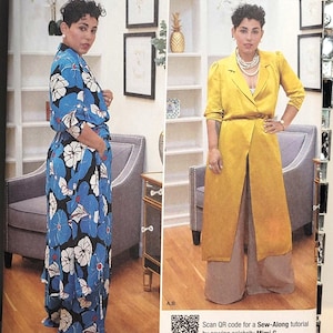 May include: Simplicity sewing pattern K8985, size U.S. 10-18, featuring Mimi G. branding. The envelope displays two garment variations: a blue floral print jumpsuit and a mustard yellow long duster coat worn over wide-leg trousers.