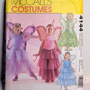 May include: McCall's Costumes 4144 sewing pattern envelope featuring illustrations of four fairy costumes with wings and layered skirts in purple, pink, green, and blue. The yellow header displays the brand name and the pattern number 4144.