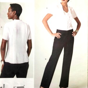 Könnte beinhalten: Ein Anne Klein New York Vogue Patterns American Designer Schnittmusterumschlag V1294, Größe B5 (8-10-12-14-16). Das Cover zeigt eine weiße kurzärmelige Bluse mit gerüschter Vorderseite und eine schwarze Hose, jeweils in Vorder- und Rückansicht.
