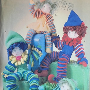 May include: A Vogue Doll Collection pattern featuring four handmade clown dolls. The dolls have striped outfits in various colors, including blue, green, and red. Each doll has a unique hat and facial expression. The pattern is designed by Linda Carr.