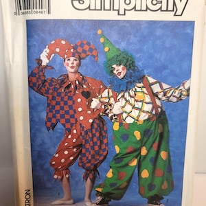 Peut inclure: Une pochette de patron de couture Simplicity, numéro 9344, taille MD, présentant deux costumes de clown. L'un a un motif à carreaux rouges et bleus avec des pois blancs, l'autre un pantalon vert à cœurs colorés et un haut à carreaux.