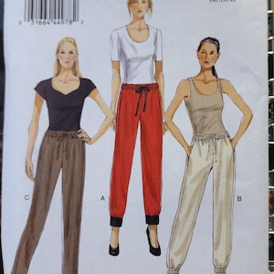 May include: A Very Easy Vogue Patterns sewing pattern, V8909, featuring illustrations of three different outfits: a black top with brown pants, a white top with red pants, and a tan top with white pants. The pattern size is Y (Xsm-Sml-Med).