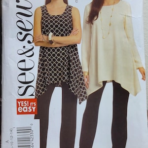May include: A sewing pattern package showing two women in different outfits. One wears a black and white circle print top with black trousers. The other wears a cream-coloured tunic and black trousers. The package has the text "see & sew" and "YES! IT'S easy".