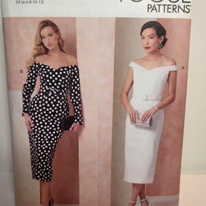 May include: Vogue Patterns V2105 sewing pattern envelope featuring two off-the-shoulder dress designs. View B is a long-sleeved black dress with white polka dots and a belt. View A is a solid white sleeveless dress with a matching belt.