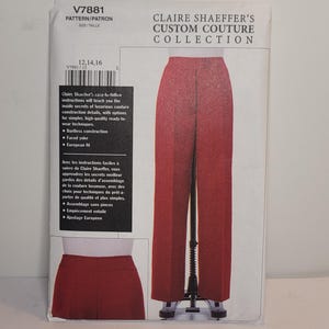 May include: A sewing pattern envelope for Claire Shaeffer's Custom Couture Collection, model V7881, featuring a pair of red trousers with a straight-leg silhouette. The packaging displays the garment on a mannequin and includes text in English and French.