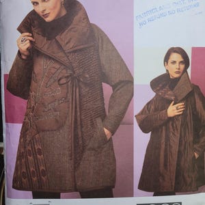 May include: A sewing pattern for a brown coat with a large collar and pockets. The pattern features a woman wearing the coat. The text on the pattern reads "KOOS COUTURE" and "VOGUE AMERICAN DESIGNER".
