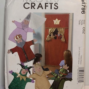 May include: McCall's Crafts M4796 sewing pattern envelope featuring illustrations of hand puppets including a king, jester, and frog, alongside a red fabric puppet theater curtain with a gold crown and gold curtains. The text reads McCall's Crafts.