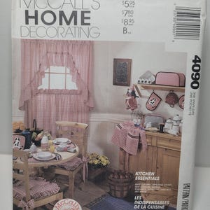 Puede incluir: Un sobre de patrón de costura McCall's Home Decorating, número 4090, que muestra ilustraciones de cortinas de cocina, fundas para electrodomésticos, cojines de asiento, servilletas, manteles individuales, agarraderas, guantes de horno y un delantal en tela de cuadros vichy roja y blanca.