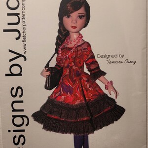 Könnte beinhalten: Ein Schnittmuster mit dem Titel Kaleidoscope für Ellowyne & Pru von Designs by Jude, das eine Puppe in einem rot gemusterten Kleid mit schwarzem Rüschensaum, lila Strumpfhose, schwarzen Absätzen, einer schwarzen Handtasche und rosa Perlenschmuck zeigt.