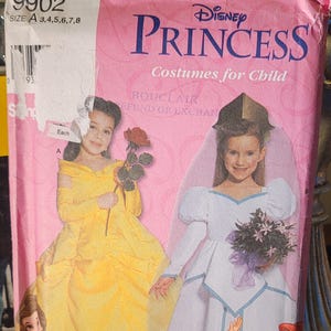 May include: Simplicity 9902 Disney Princess costumes for children. The pink package features illustrations of Belle and Aurora in their princess gowns. The package also includes the price of £10.30.