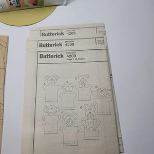 Factory folded uncut tissue pattern pieces and instruction booklet for Butterick B4209 hand puppet pattern laid flat and never opened