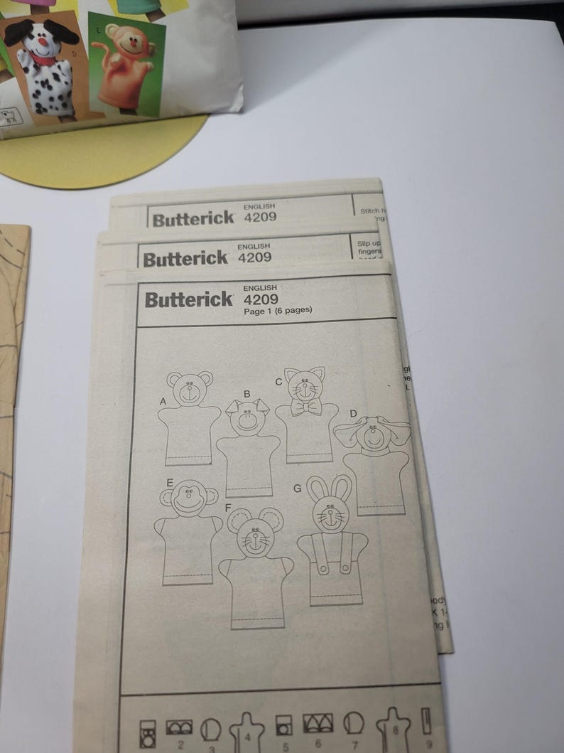 Factory folded uncut tissue pattern pieces and instruction booklet for Butterick B4209 hand puppet pattern laid flat and never opened