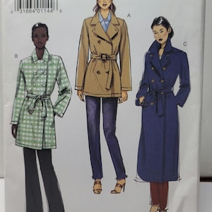 Op de afbeelding: Een Very Easy Vogue naaipatroon envelop V9367/Y voor maten XSM-SML-MED. De voorzijde toont drie illustraties van dubbelrijige jassen: een groen-wit geblokte jas, een beige jas met ceintuur en een lange donkerblauwe jas met ceintuur en knopen.