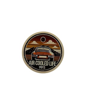 Puede incluir: Pegatina redonda con un diseño retro. Presenta un coche Porsche 911 naranja sobre un fondo de puesta de sol y montañas. El texto dice "AIR COOLED LIFE 9911". El diseño tiene una estética vintage.
