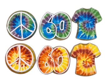 May include: Six tie-dye decorated cookies, two peace signs, two numbers "60", and two t-shirts. The cookies are decorated in blue, green, yellow, and orange.