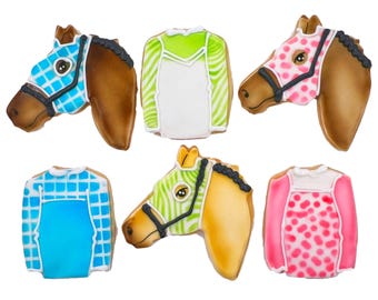 Puede incluir: Seis galletas de azúcar decoradas con forma de caballos y sedas de jockey. Las galletas están decoradas con varios colores y patrones, incluyendo azul, verde, rosa y blanco.