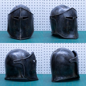 Op de afbeelding: Vier aanzichten van een donkergrijze middeleeuwse helm. De helm heeft een kruisontwerp en een vizier met oogspleten. Het oppervlak heeft een verweerde, verouderde uitstraling. Het ontwerp suggereert historische of fantasiethema's.