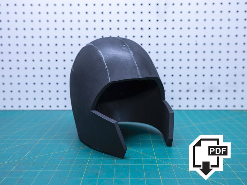 May include: A black foam helmet with a visor. The helmet is on a green cutting mat. PDF.