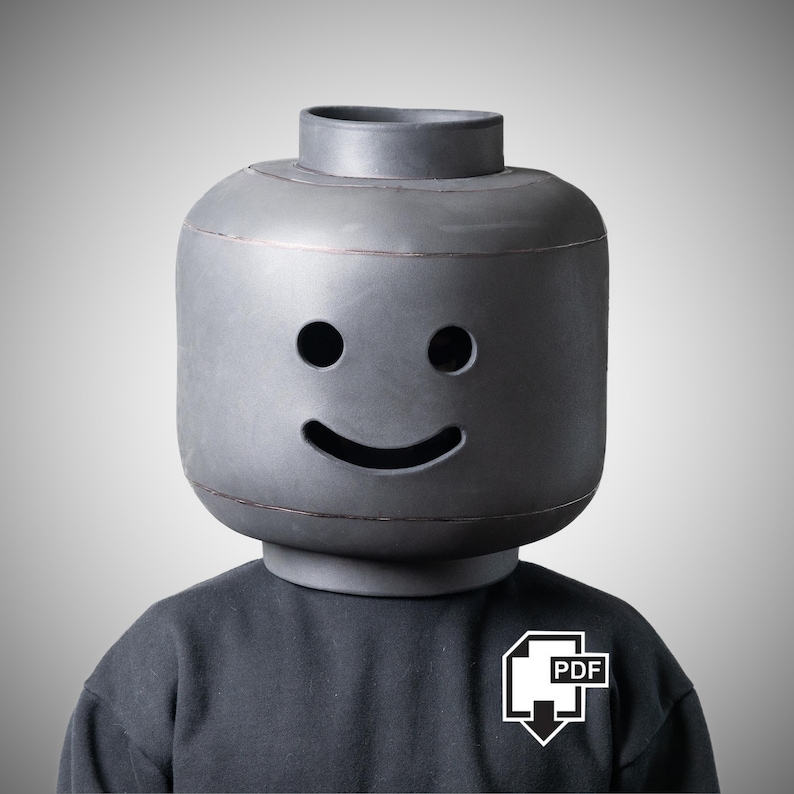 May include: A person wearing a large, grey Lego-style head with a smiling face. The person is wearing a dark grey sweatshirt with a white PDF icon on the chest.