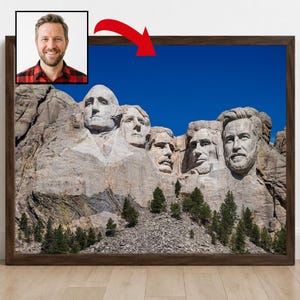 Può includere: Una stampa artistica incorniciata del Mount Rushmore National Memorial con il ritratto di un uomo con barba e camicia a quadri rossi integrato come quinto volto scolpito sul lato destro, su uno sfondo di cielo blu intenso e limpido.