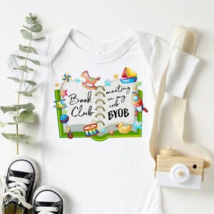 Puede incluir: Un body blanco para bebé con un diseño de libro verde. El libro está decorado con una variedad de juguetes coloridos, incluyendo un caballito de balancín, un barco, un cohete, un tambor y un pato de goma. El texto en el libro dice "Book Club meeting in my crib BYOB".
