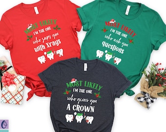 Könnte beinhalten: Drei Weihnachts-T-Shirts mit einem Zahnthema. Das rote Shirt sagt "Most Likely I'm the one who saps you with X-rays". Das grüne Shirt sagt "Most Likely I'm the one who asks you questions". Das dunkelblaue Shirt sagt "Most Likely I'm the one who gives you a crown".