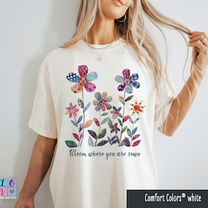 Peut inclure: T-shirt blanc avec un motif floral coloré et le texte "Bloom where you are sewn".