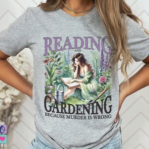 May include: A light gray t-shirt featuring a graphic with the words "READING and GARDENING" in purple, with a woman reading in a garden. The text "BECAUSE MURDER IS WRONG" is below. A small logo is in the bottom left corner.