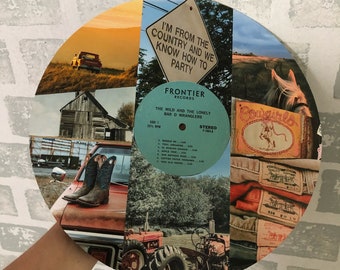May include: A circular collage featuring country-themed images, including a vintage truck, cowboy boots, a barn, and a tractor. The collage incorporates a vinyl record and the text "I'M FROM THE COUNTRY AND WE KNOW HOW TO PARTY."