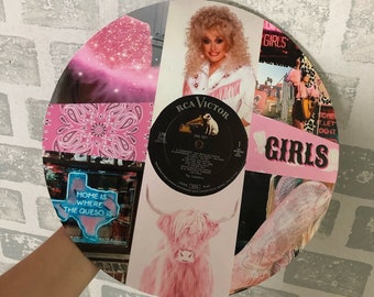 May include: A collage on a vinyl record featuring images of Dolly Parton, a pink Highland cow, a pink bandana, and a neon sign that reads "HOME IS WHERE THE QUESO IS." The record also includes the text "GIRLS."