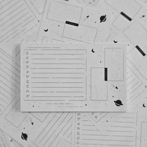 May include: A collection of black and white stationery with celestial designs. The main piece features a lined section, boxes, and star and planet illustrations. The text "TODAY'S MOOD MADE WORDS... IN LOVE WITH YOU" is visible.